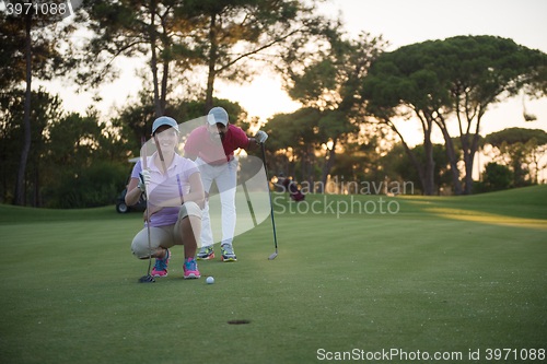 Image of couple on golf course at sunset
