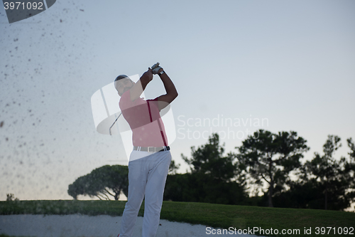 Image of golfer hitting a sand bunker shot on sunset