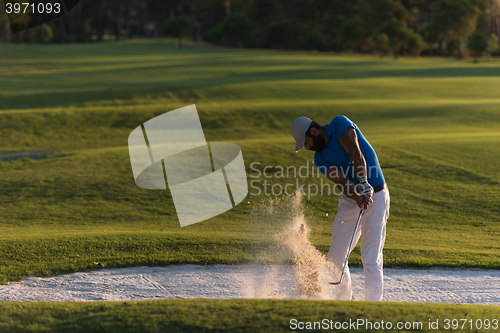 Image of golfer hitting a sand bunker shot on sunset