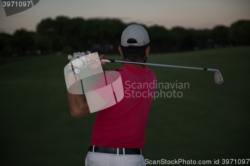 Image of golfer hitting a sand bunker shot on sunset