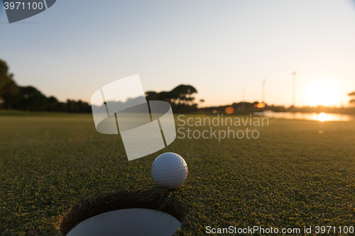 Image of golf ball on edge of  the hole