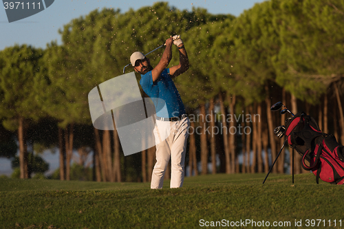 Image of golfer hitting a sand bunker shot on sunset