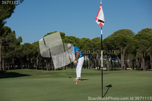 Image of golf player hitting shot at sunny day