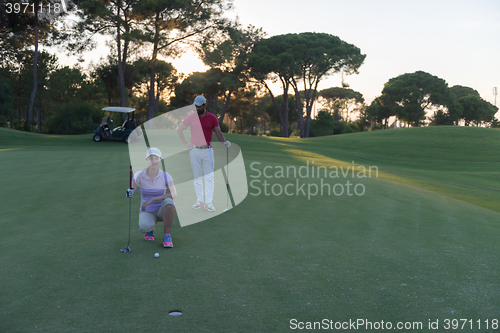 Image of couple on golf course at sunset