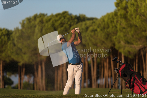 Image of golfer hitting a sand bunker shot on sunset