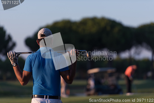 Image of golfer from back at course looking to hole in distance
