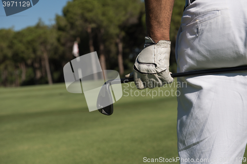 Image of golf player close up hand and driver from back