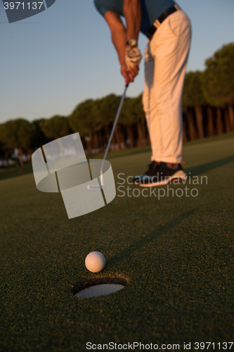 Image of golfer  hitting shot at golf course