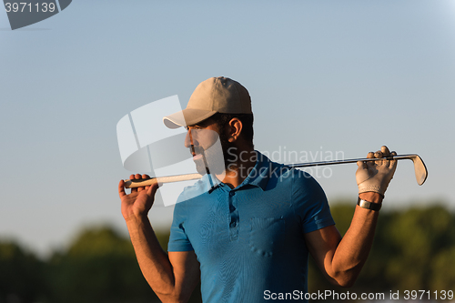 Image of golfer  portrait at golf course on sunset