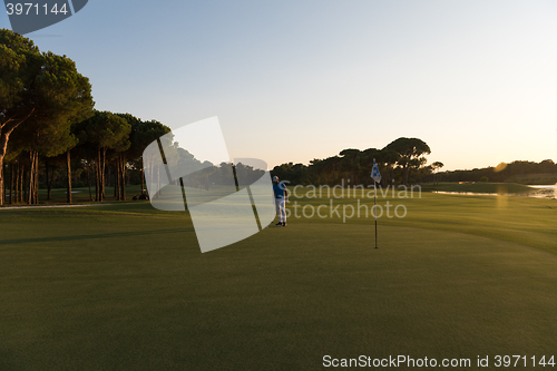 Image of golfer hitting ball to hole