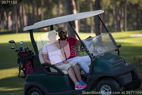 Image of couple in buggy on golf course