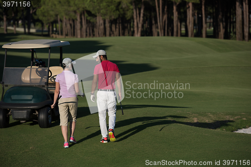 Image of couple walking on golf course