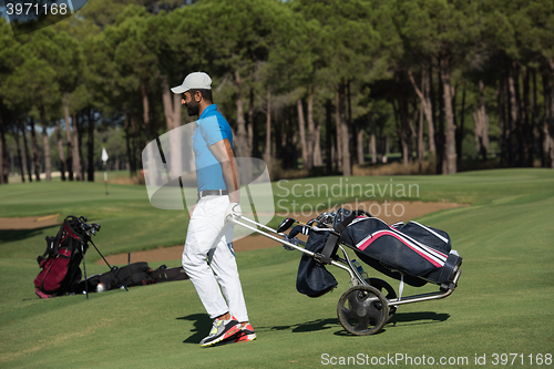 Image of golf player walking with wheel bag