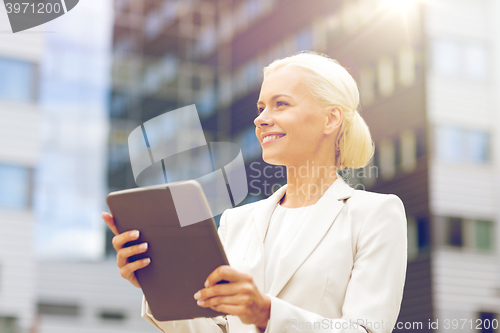 Image of smiling businesswoman with tablet pc outdoors
