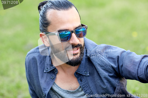 Image of man in sunglasses at city street or park
