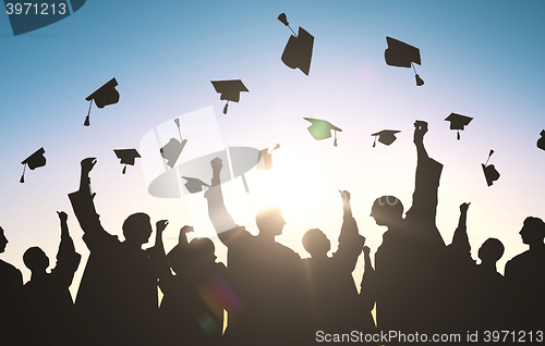 Image of silhouettes of students throwing mortarboards