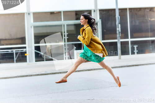 Image of happy young woman or teenage girl on city street