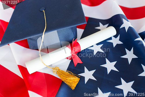 Image of bachelor hat and diploma on american flag