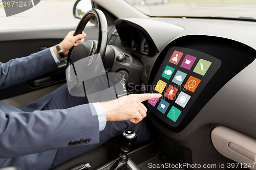 Image of man driving car with menu icons on board computer