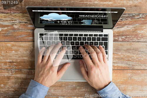 Image of close up of male hands with laptop typing