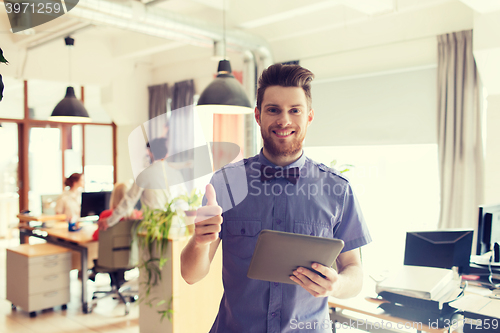 Image of happy creative male office worker with tablet pc