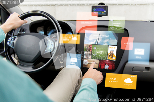 Image of man driving car with news on board computer