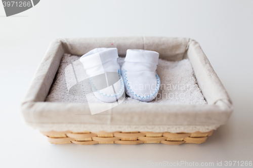 Image of close up of baby bootees for newborn boy in basket