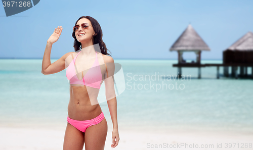 Image of happy woman in sunglasses and bikini on beach