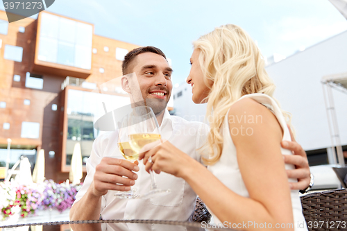 Image of happy couple drinking wine at open-air restaurant