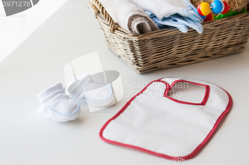 Image of close up of baby bootees, bib and newborn stuff