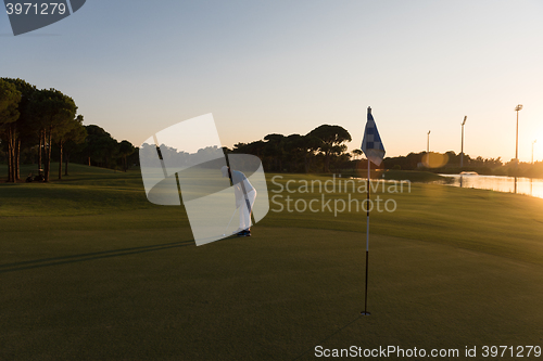 Image of golfer hitting ball to hole