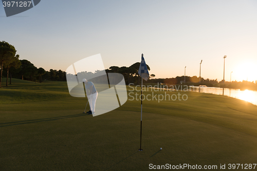 Image of golfer hitting ball to hole