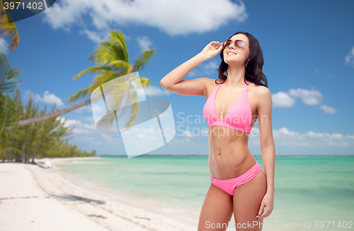 Image of happy woman in pink bikini swimsuit on beach