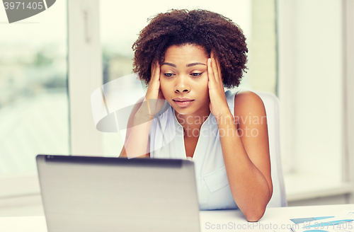 Image of african woman with laptop at office