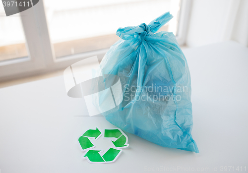 Image of close up of rubbish bag with green recycle symbol