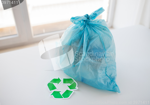 Image of close up of rubbish bag with green recycle symbol