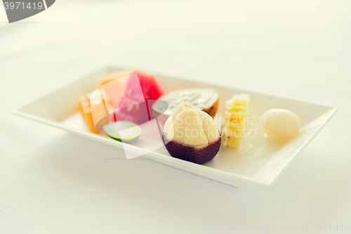 Image of plate of fresh juicy fruit dessert at restaurant