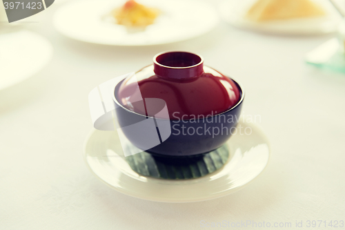 Image of ceramic pot with hot dish on restaurant table