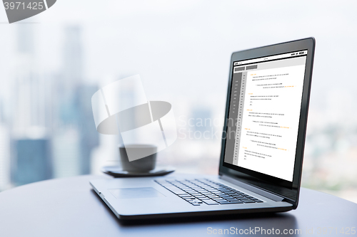 Image of close up of laptop and coffee cup on office table