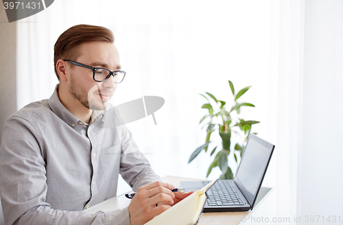 Image of creative man or businessman writing to notebook