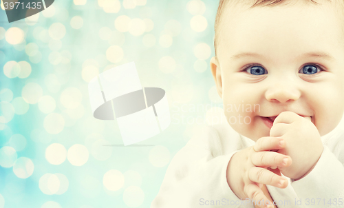 Image of happy baby face over blue holidays lights