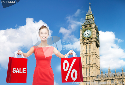 Image of young happy woman with shopping bags over big ben