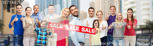 Image of happy people with sale sign showing thumbs up