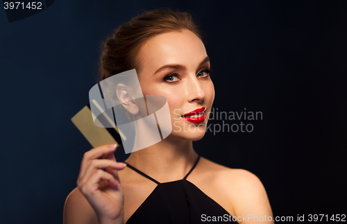Image of beautiful woman with credit card over black