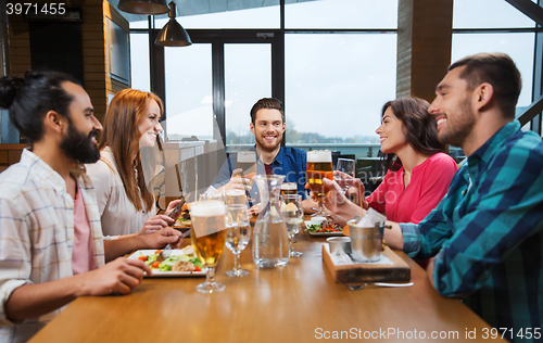Image of friends dining and drinking beer at restaurant