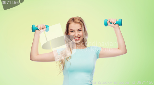 Image of smiling beautiful young sporty woman with dumbbell