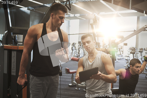 Image of men exercising on gym machine