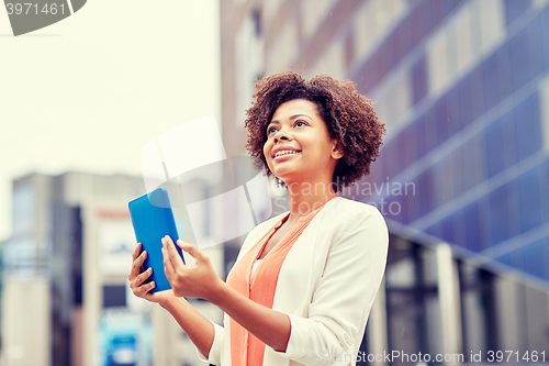 Image of happy african businesswoman with tablet pc in city