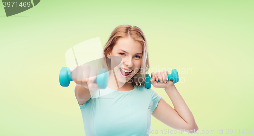 Image of smiling beautiful young sporty woman with dumbbell