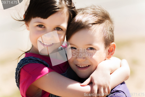 Image of two happy kids hugging outdoors